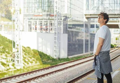 Distant plan of young attractive man waiting for train in metro station. Stock Photos