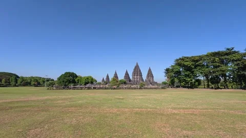 Distant Prambanan Temple spires rise across a spacious tropical field benea.. Stock Footage 341542801