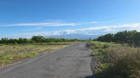 Distant Road Through Open Landscape with Mountains Stock Footage 336387364
