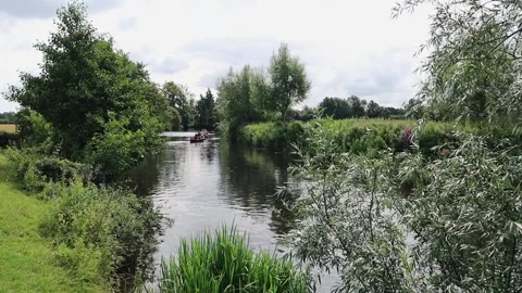 Distant rowing boats on river Stour between Dedham and Flatford Mill Stock Footage 180048422