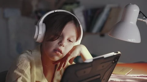 Distant School Learning Concept. Girl in Headphones Uses Tablet Computer Stock Footage 252969936