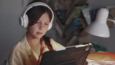 Distant School Learning Concept. Girl in Headphones Uses Tablet Computer Stock Footage 253438001