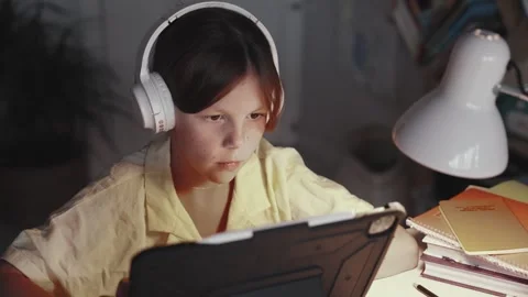 Distant School Learning Concept. Girl in Headphones Uses Tablet Computer Stock Footage 253647788