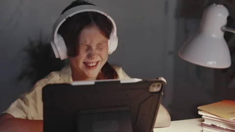 Distant School Learning Concept. Girl in Headphones Uses Tablet Computer Stock Footage 256668043