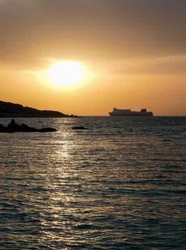 A distant ship sailing in an open sea on sunset Fotos Stock