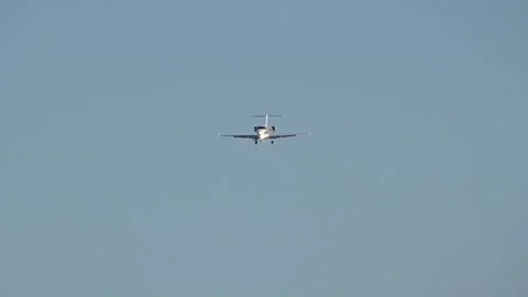 Distant shot of light private jet making final approach for landing at airport Stock Footage 265471791