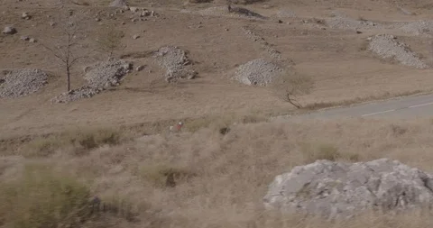 Distant side view of two cyclist riding fast on hills Video stock 108721375