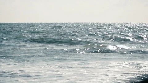 Distant slow motion view of small turquoise waves building before storm Stock Footage 119534505