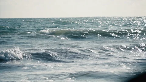 Distant slow motion view of small turquoise waves building before storm v2 Stock Footage 119534720