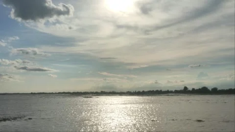 Distant Small Boat Driving Across Wide Calm Lake Water Under Sunset Sky In C Stock Footage 341647858