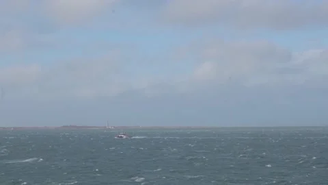 Distant small tug sails across boundless sea in heavy storm Stock Footage 135443456