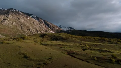 Distant snow-capped peaks stand against a cloudy sky Vídeo Stock 338200770