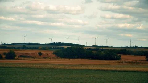 Distant spinning wind generators and field in Austria Stock Photos