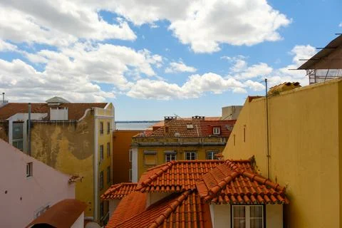 Distant Tagus River peaks from behind residential buildings in the heart of.. Photos