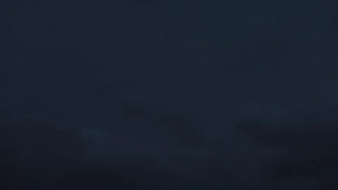 Distant thunderclouds glowing with lightning in dark night sky Video stock 337854961