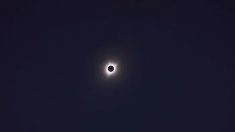Distant total solar eclipse changing to reveal bright lens flare / Driggs, Stock Footage 83190041