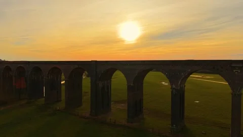 Distant train bridge seen from above at golden hour. Scenic aerial shot of Stock Footage 306538728