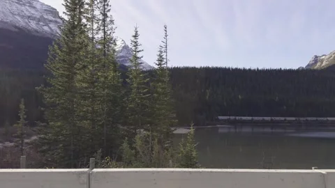 Distant Train Passing Mountain Lake in the Canadian Rockies Stock Footage 345451834