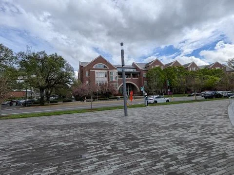 Distant view across a paved courtyard looking toward brick university campus 库存照片