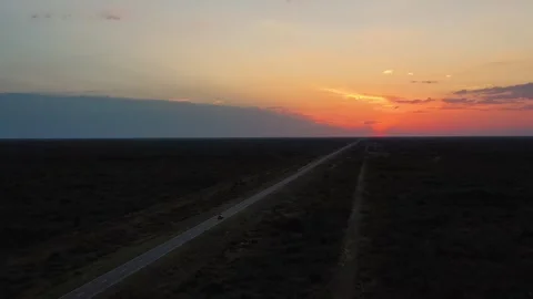 Distant view of adventurer driving on straight highway through the desert Stock Footage 264095458