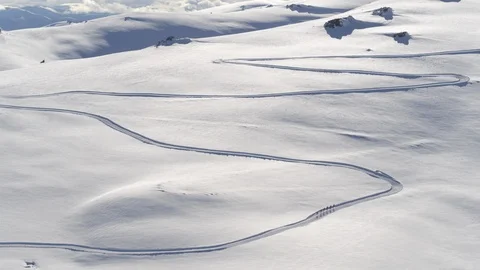 Distant view aerial of pro athletes cross-country skiing on trail in remote area Stock Footage 121584057