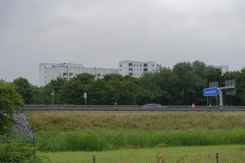 Distant View of Autobahn with Blue Exit Sign and White Buildings Stock Photos