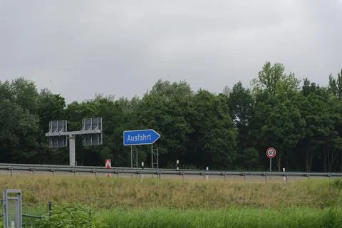 Distant View of Autobahn Exit Sign and Speed Limit Sixty Stock Photos
