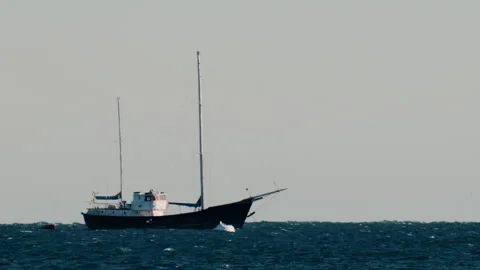 Distant view of a boat moving on the sea in the evening Stock Footage 295673142