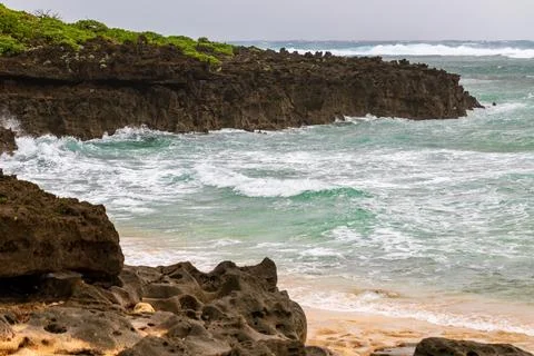 A distant view of the clear waves and reefs of Ike Island Stock Photos