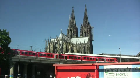Distant view of Cologne cathedral spires with trains passing on raised track. Stock Footage 51774752