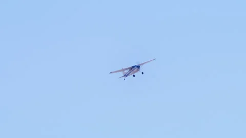 Distant view of generic small private single engine airplane flying in blue sky Stock Footage 231167650
