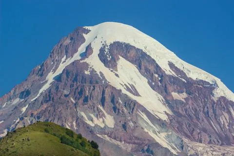 Distant view on Gergeti Trinity Church in Stepansminda, Georgia. Clear sky above Stock Photos