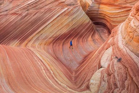Distant View of Hiker Crossing Iconic The Wave Stock Photos