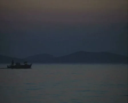 Distant view of motorboat at dusk Stock Footage
