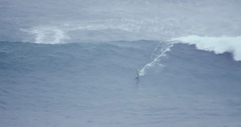 Distant view of pro surfer surfing on big ocean wave during cloudy day Stock Footage 157707926