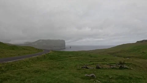 Distant view of Risin og Kellingin sea stacks from a mountain road, Faroe Island Stock Footage 339946592