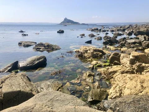 Distant View Of St Michaels Mount Across The Rocky Sea Shore Foto stock