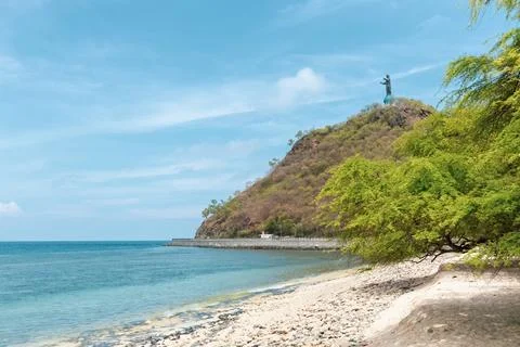 Distant view of Statue of Cristo Rei of Dili against the sun rays in Timor Le Fotos Stock