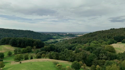 A distant village with a castle in between green forests, hills and fields Stock Footage 248089417