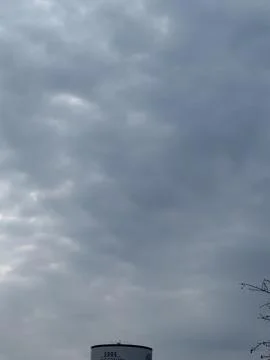 Distant Water Tower Beneath Cloudy Sky Stock Photos