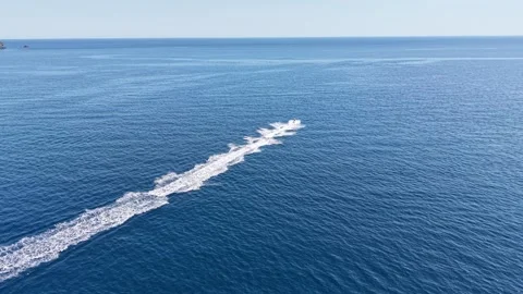 Distant Watercraft Leaving Long Wake Across Blue Sea Stock Footage 340508576