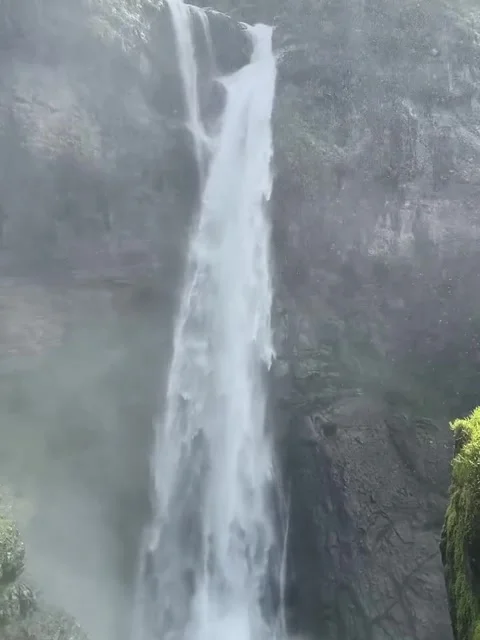 Distant Waterfall Flowing into Mist-Filled Canyon Basin Stock-Footage 341320302