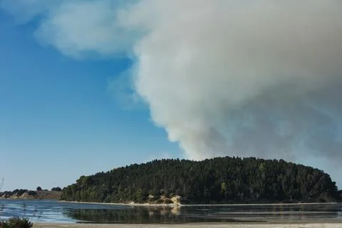A distant wildfire sends a towering column of smoke in Albania Stock Photos