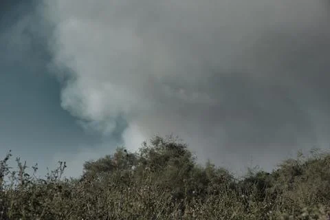 A distant wildfire sends a towering column of smoke in Albania Stock Photos