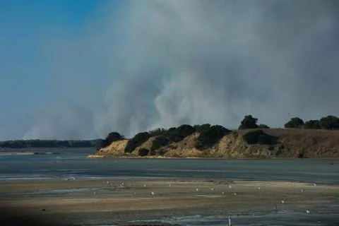 A distant wildfire sends a towering column of smoke in Albania Stock Photos