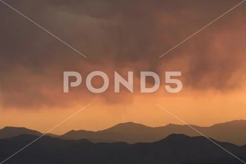 Distant wildfires and mountains at sunset in Denver, Colorado Stock Photos
