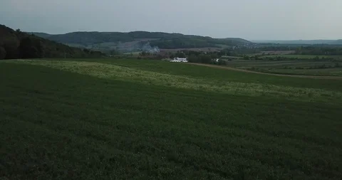 Distant Wind Mills and Farm Fields - Pan Backwards with Tilt Upwards Stock Footage 109136103