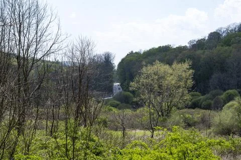 Distant winding road cuts through a lush green valley Stock Photos