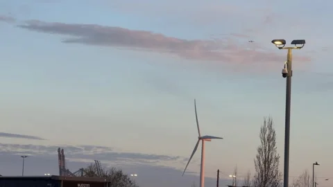 Distant windmill turning under airplane slow motion Stock Footage 330948114