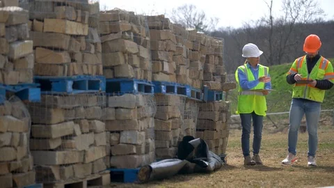 Distant woman project engineer reviewing and job foreman walk towards camera Stock Footage 127123701